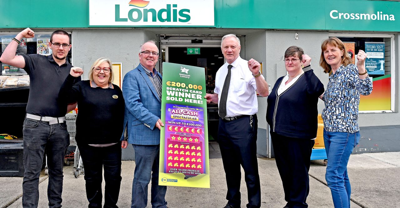 NO REPRO FEE: 19th July 2023. Hiney’s Londis shop in Crossmolina, Ballina, Co. Mayo were thrilled to hear that one of their customers scooped the top prize of €200,000 on an All Cash Spectacular scratch card. Staff members Kevin Bracken, Annette Gray, Pauric Gillespie, National Lottery, Shop Owner Enda Hiney, Agnes Winter and Helen Keane pictured here outside the shop as they celebrate the win. Pic: Conor McKeown / Mac Innes photography