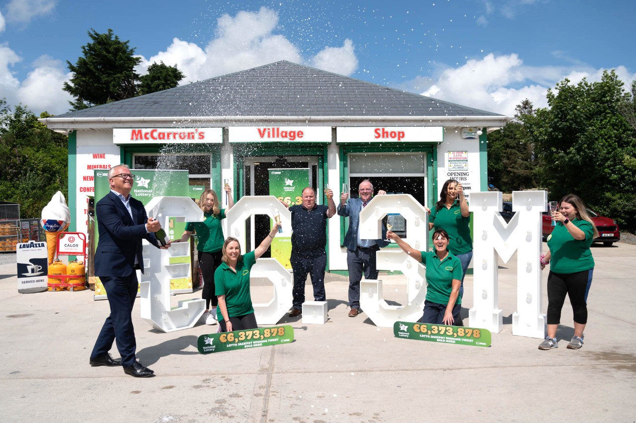 Jim O'Connor, National Lottery breaks opens the Champaign as Hugh McCarron and Pauric Gillespie, National Lotter  his staff Clare McMonagle, Andrea Ruddy, Sandra Hegarty, Lauren Crumlish and Deena Patterson from McCarrons Village Shop, Quigleys Point celebrate  selling one of a €6.3M winning lottery ticket. Pic: Clive Wassen / Mac Innes Photography